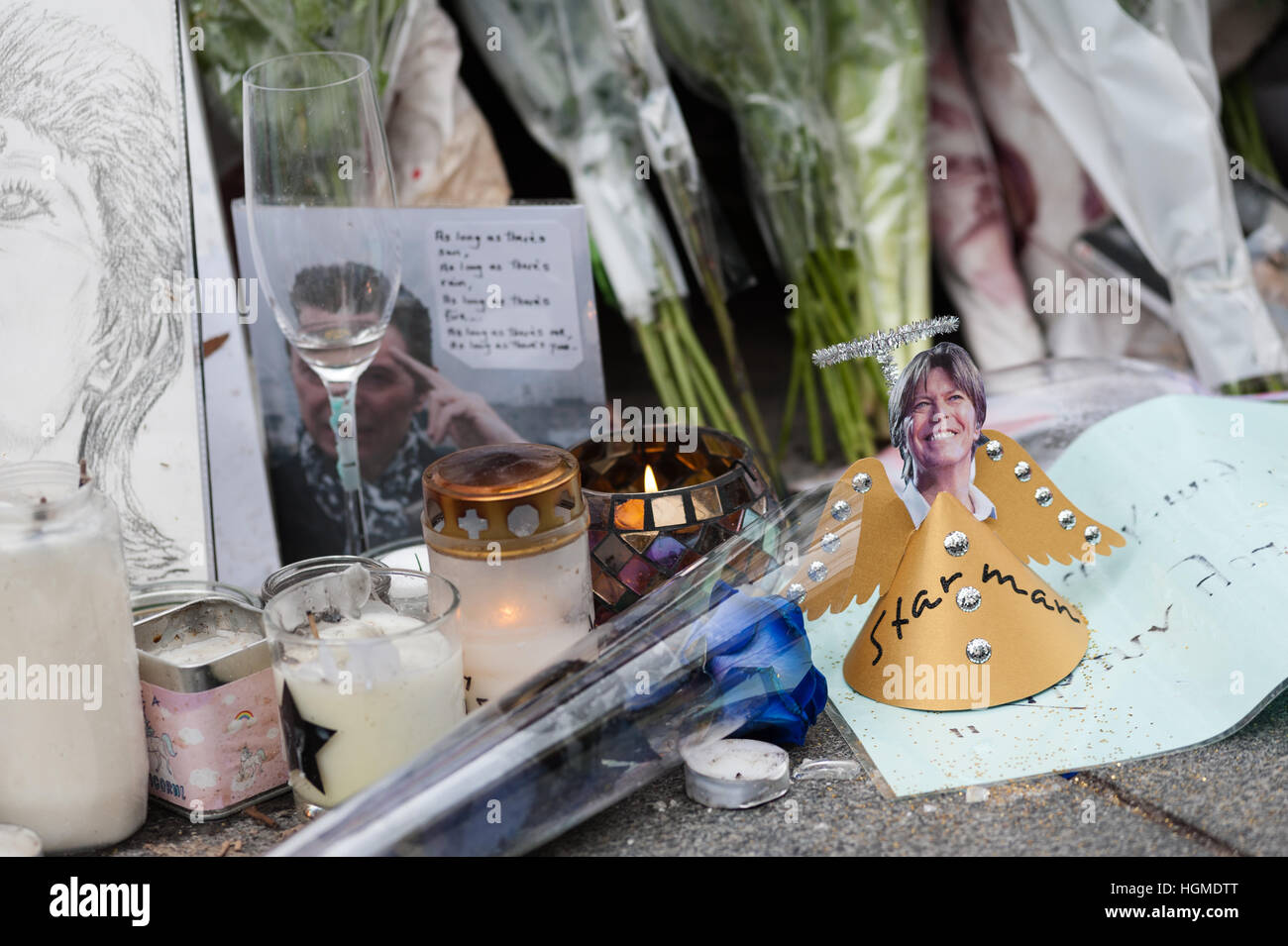 London, UK. 10. Januar 2017. Fans sammeln durch das Wandbild von David Bowie im Geburtshaus des Künstlers Brixton zum Gedenken an den ersten Todestag des Musikers. Brixton Wandbild, Bowies Gesicht von Aladdin Sane Albumcover zeigt, wurde der große Gedenkstätte nach der Star-Tod am 10. Januar 2016. Wiktor Szymanowicz/Alamy Live-Nachrichten Stockfoto