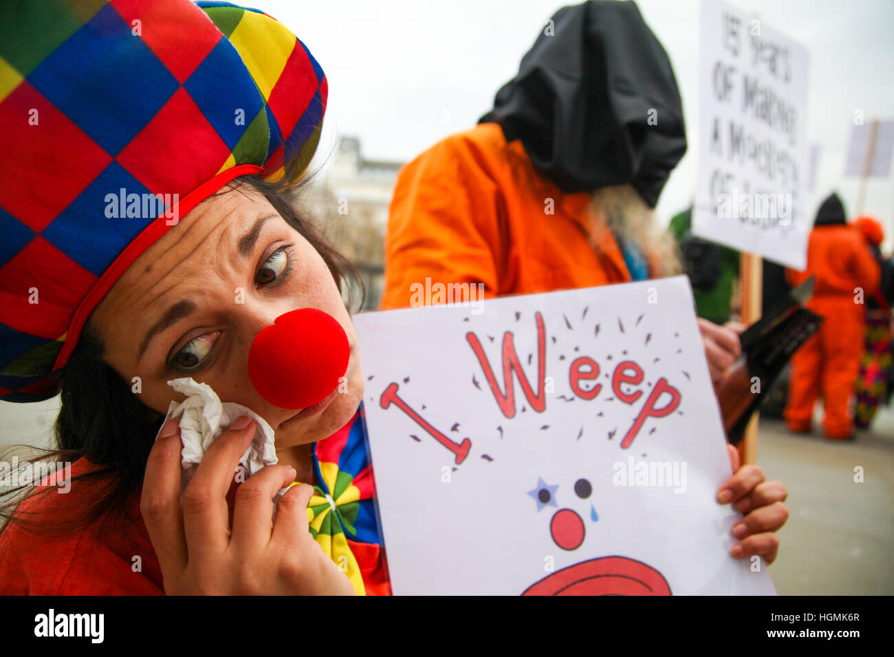 Die London Guantánamo Kampagne und Menschenrechtsaktivisten markiert den 15. Jahrestag der Eröffnung des das Gefangenenlager Guantánamo Bay mit einem traurigen Clown Protest außerhalb der National Gallery Stockfoto