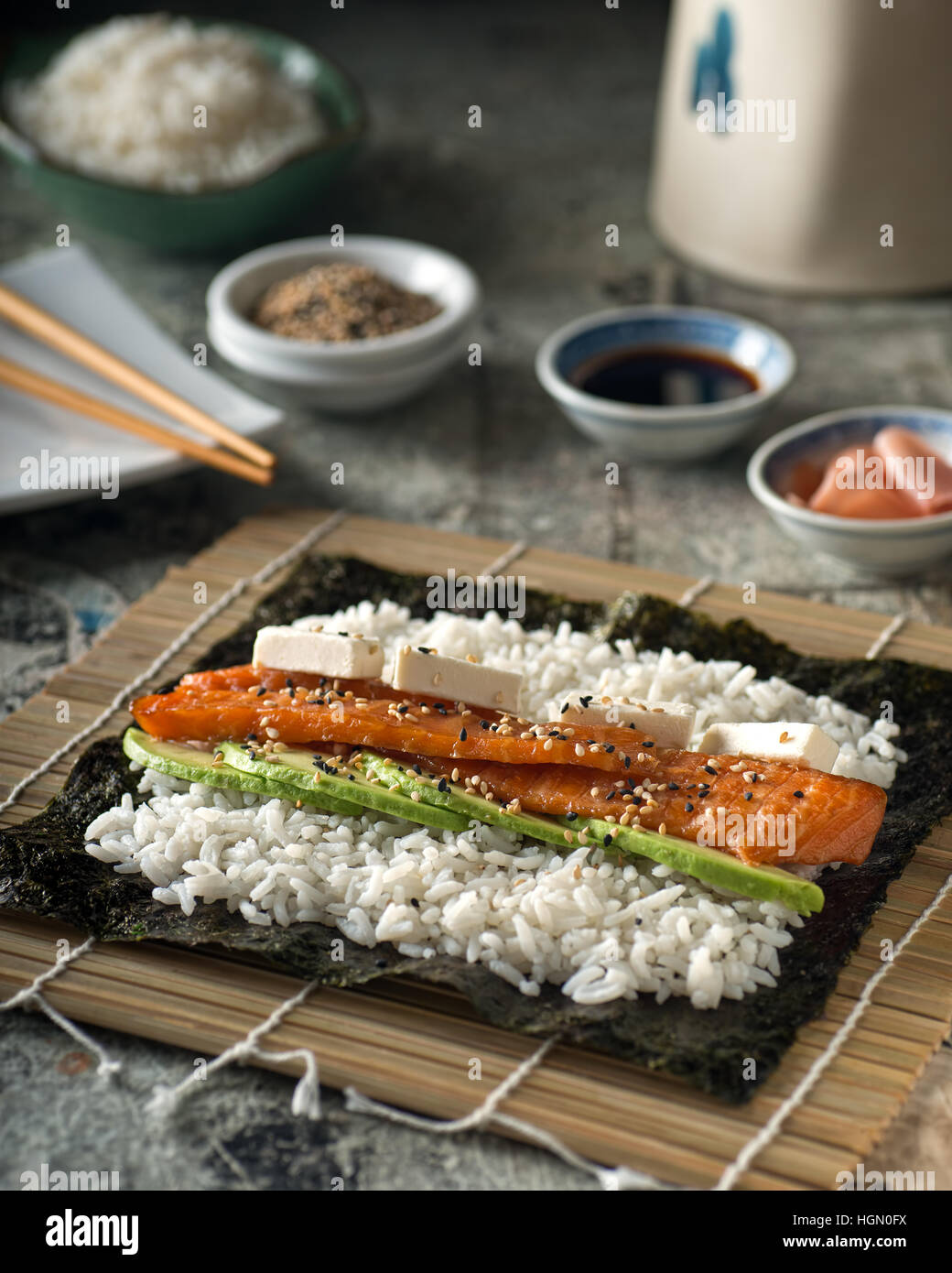 Ein köstliches geräucherter Lachs Sushi-Rolle mit Avocado, Sahne Käse und gerösteten Sesam. Stockfoto