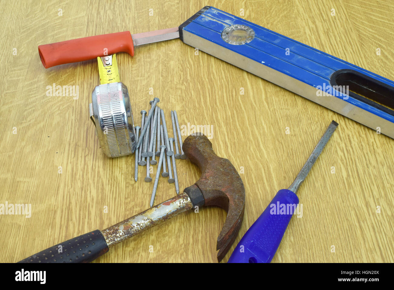 Hammer, Nägel, Messer, Lineal, Wasserwaage und Meißel auf den Tisch. Stockfoto
