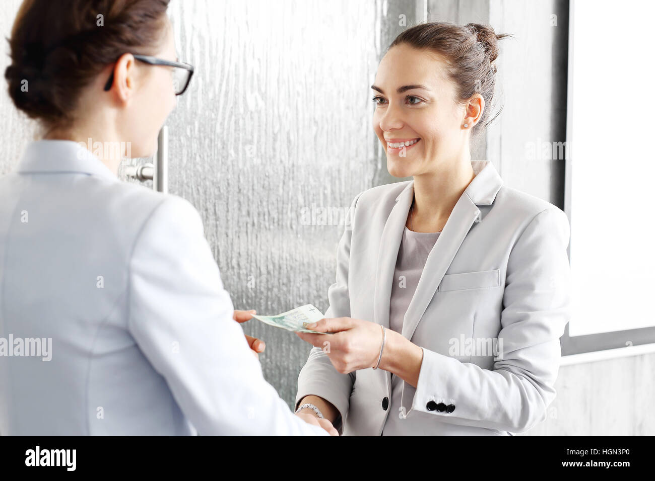 Geld. Datei-Banknoten übergeben von Hand zu Hand. Die Vergütung für die geleistete Arbeit. Eine Frau zahlt den Arbeitnehmer. Stockfoto