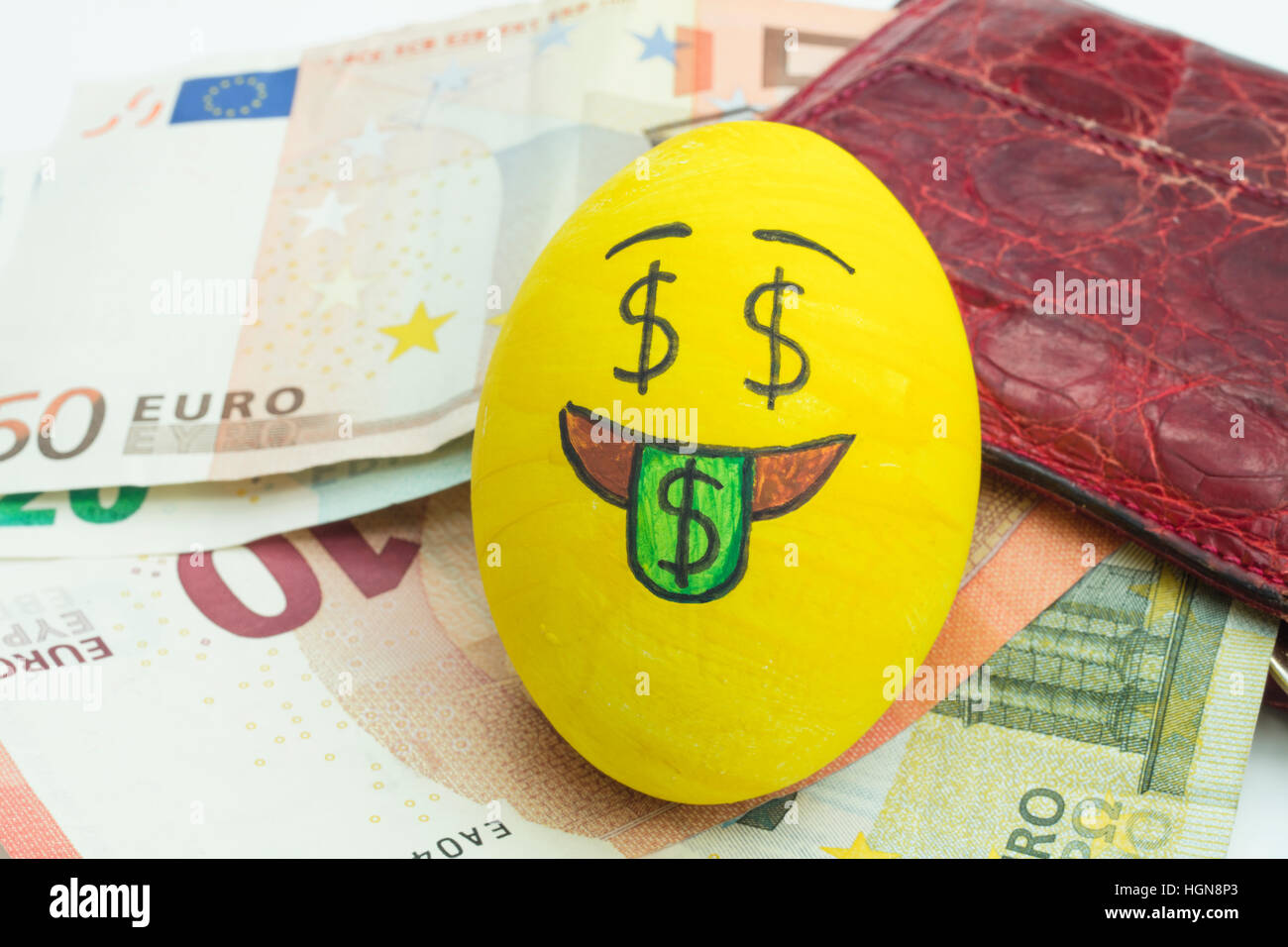 Emoji Osterei mit Gesichtsausdruck "Ich liebe Geld' auf Papiergeld Euro platziert. Stockfoto