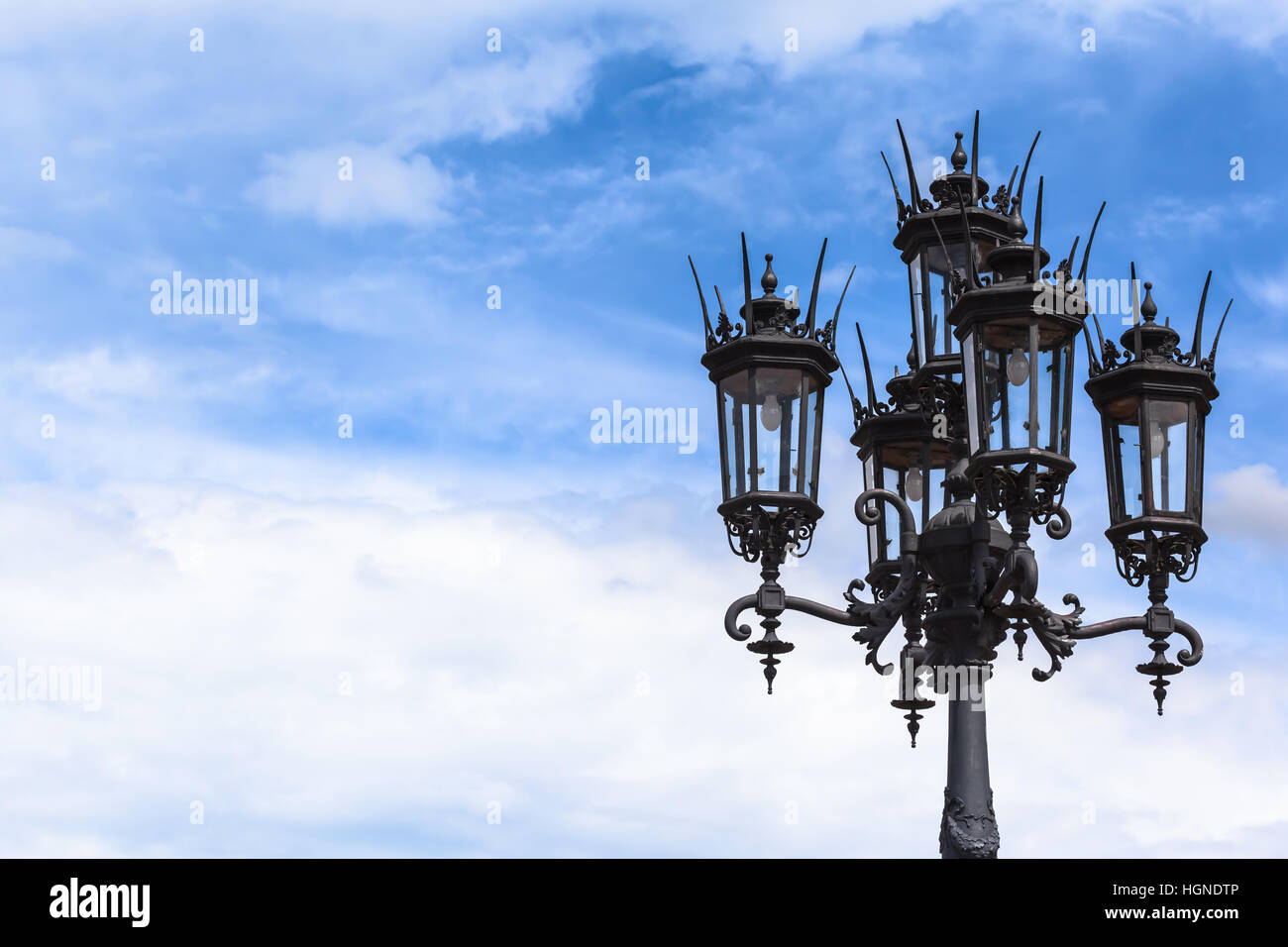 Historische Form schwarzen Laternenpfahl mit fünf Laternen vor blauem Himmel und Wolken Hintergrund (textfreiraum) Stockfoto