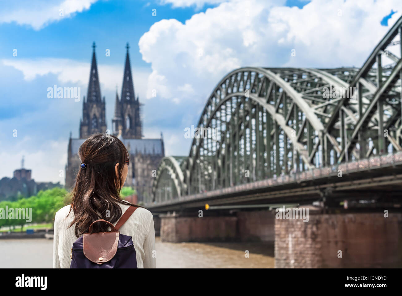 Junge Frau aus rückblickend Fluss Rhein gesehen, riesige Brücke und den berühmten Dom von Köln, Deutschland Stockfoto