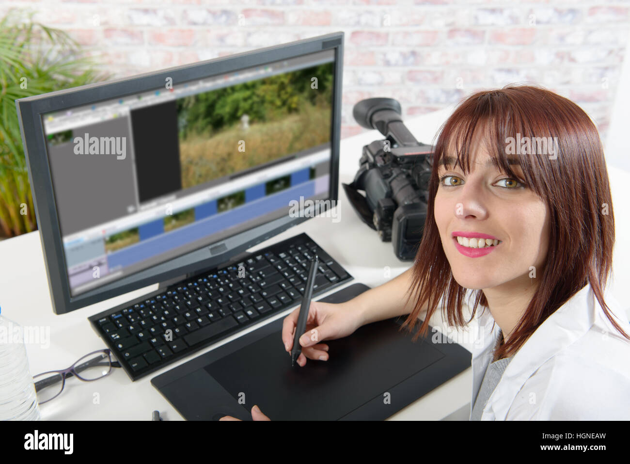 lächelnde Frau Jungdesigner mit Computer für den Videoschnitt Stockfoto
