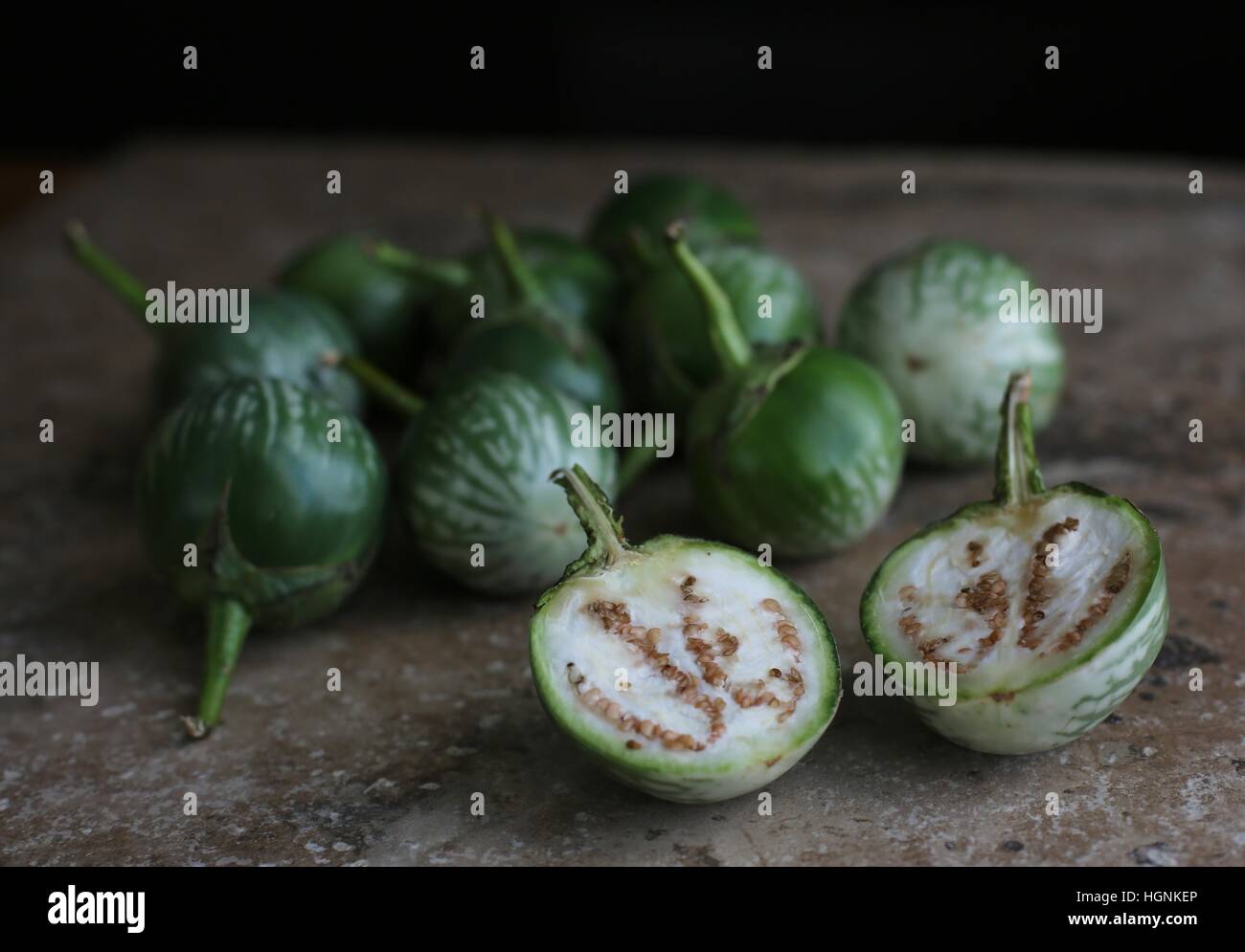 Eine Reihe von Thai Auberginen, mit einem in zwei Hälften geschnitten. Stockfoto