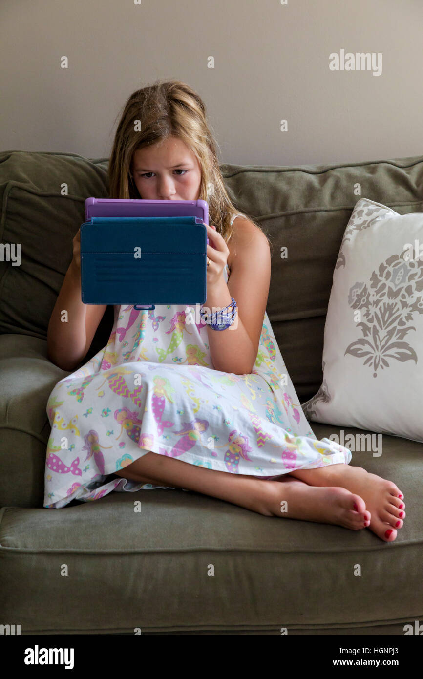Eleven-Year-Old Girl Spiel auf dem iPad. Stockfoto