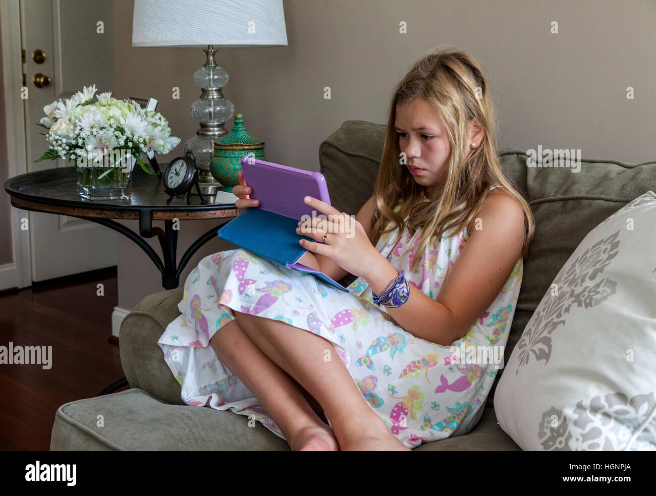Eleven-Year-Old Girl Spiel auf dem iPad. Stockfoto