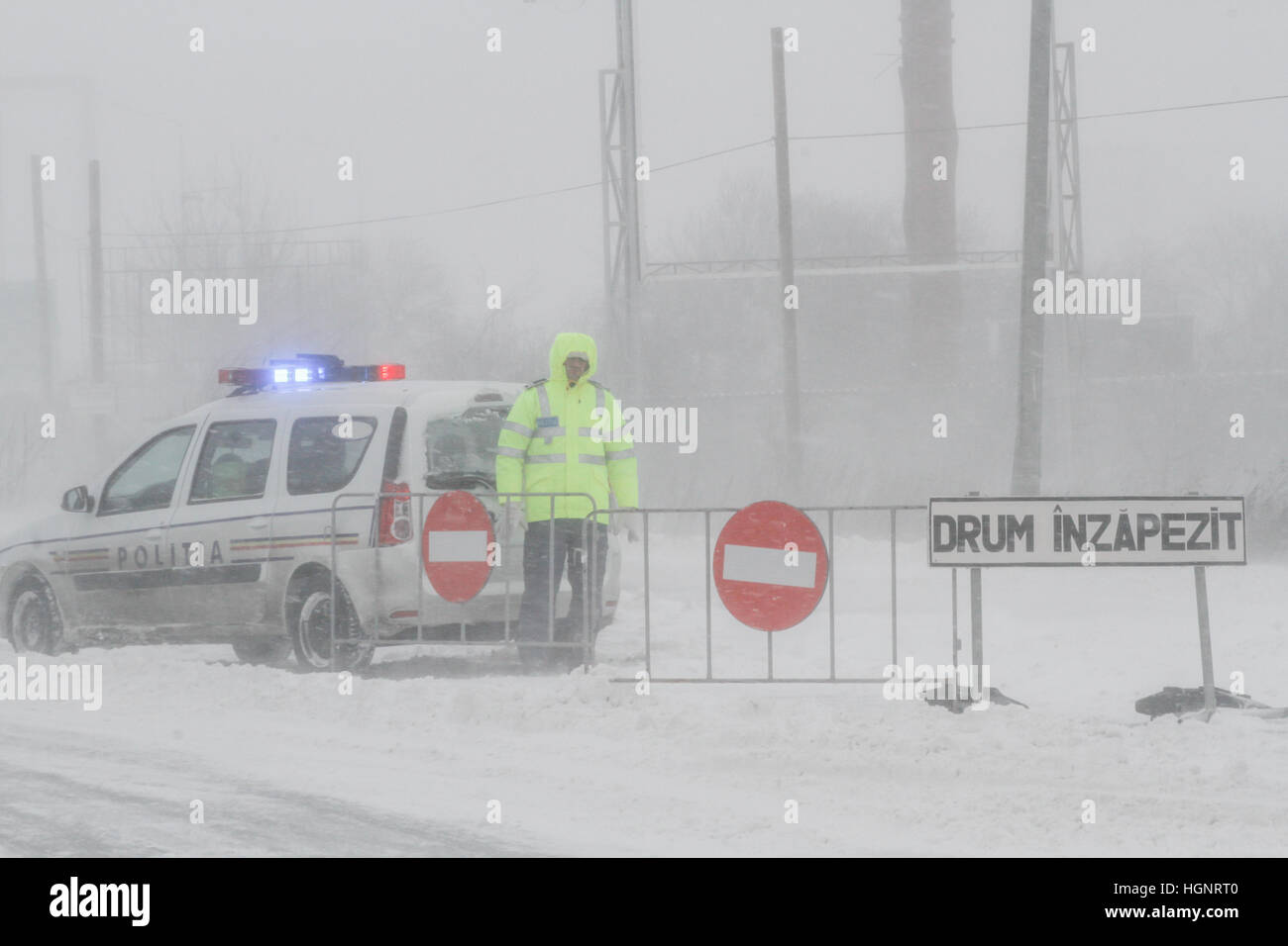 Bukarest, Rumänien, 25. Januar 2016: Ein Polizist bleibt neben einem geschlossenen Straße während eines Schneesturms in Bukarest. Stockfoto