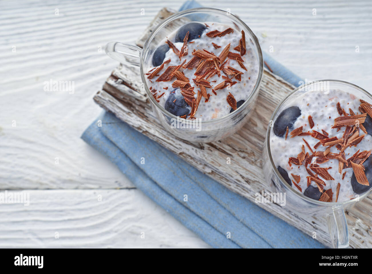 Chia Pudding mit Trauben und Schokolade Flocken auf dem horizontalen weißen Holztisch Stockfoto