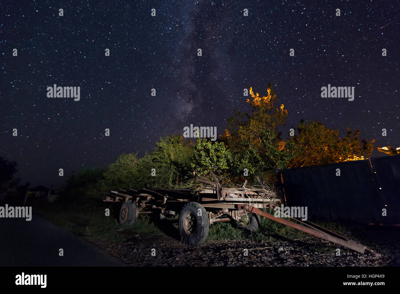 Nachtszene im Dorf mit einem alten Wagen und der Milchstraße am Himmel, Kasachstan Stockfoto