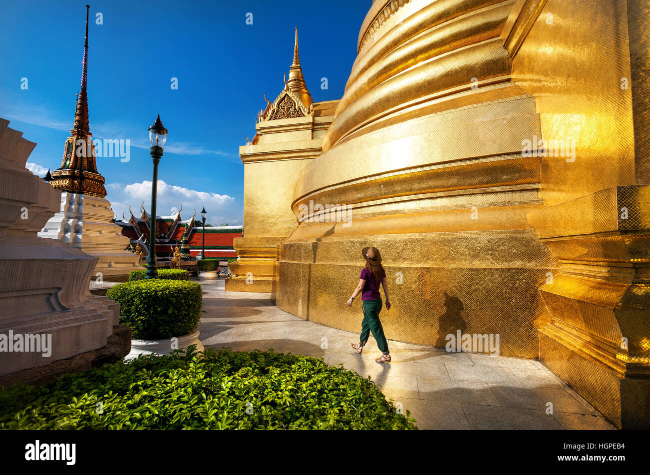 Frau Touristen zu Fuß in den Tempel des Smaragd-Buddha mit goldenen Stupa in Bangkok bei Sonnenuntergang Stockfoto