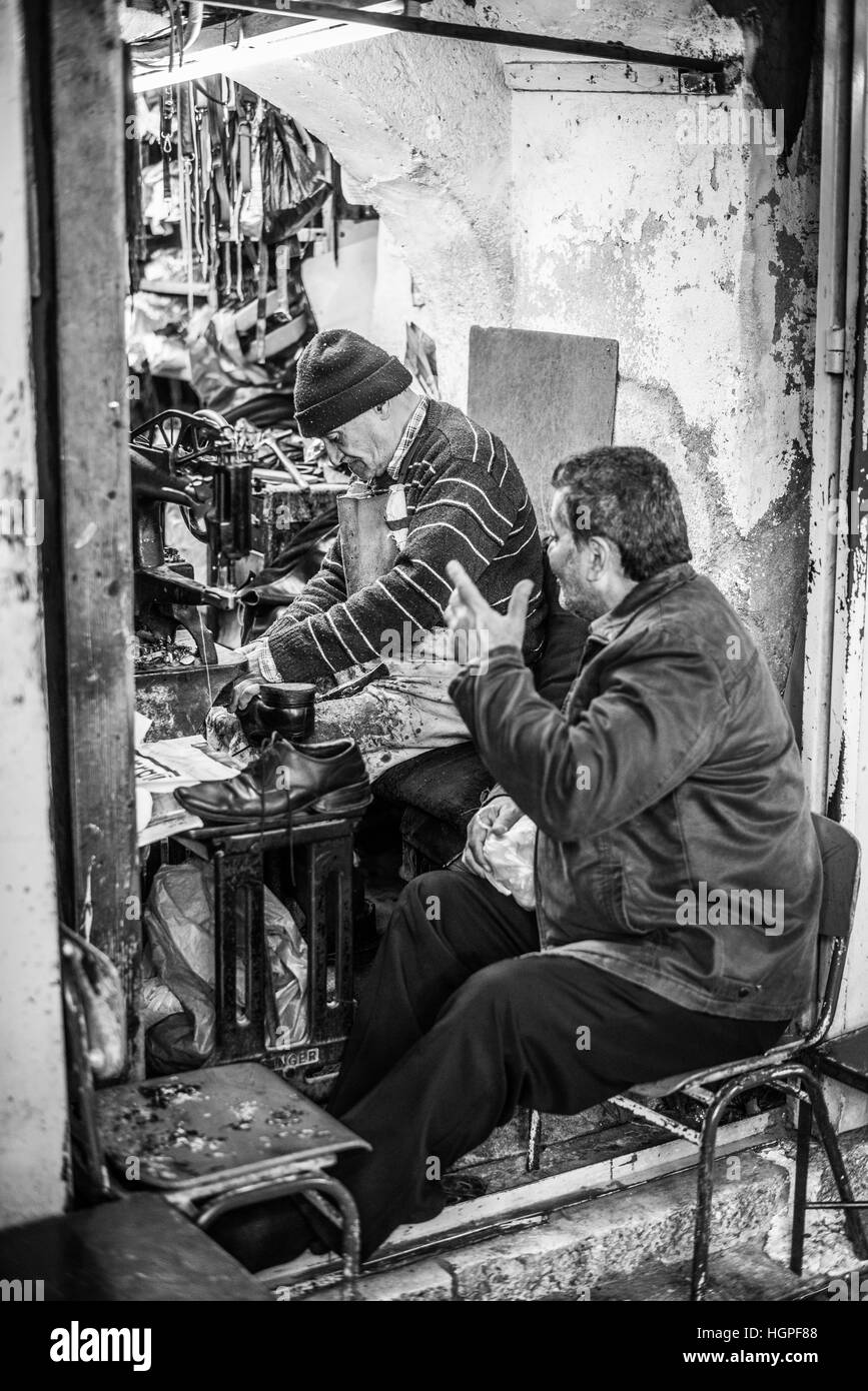 Mann sitzt vor einem Schuhmacher-Werkstatt in der Jerusalemer Altstadt, Israel Stockfoto