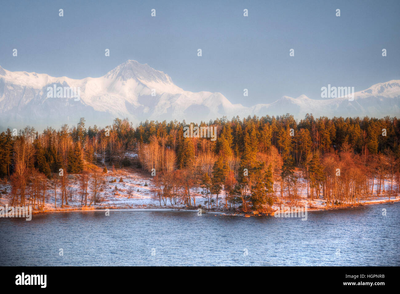 Wald im Licht der untergehenden Sonne im Hintergrund Berge und Flüsse Stockfoto