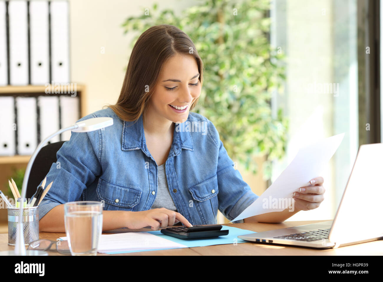Freie Frau Berechnung ein Budget in einem Desktop im Büro Stockfoto