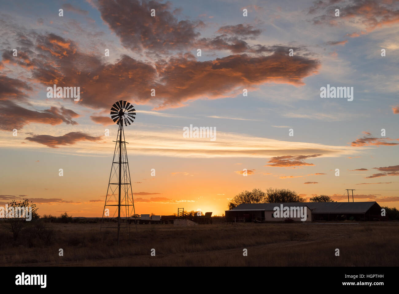 Eine Wasser-Pumpen Windmühle bei Sonnenuntergang auf einem Bauernhof in der Nähe von Ritchie in der Northern Cape Provinz von Südafrika Stockfoto