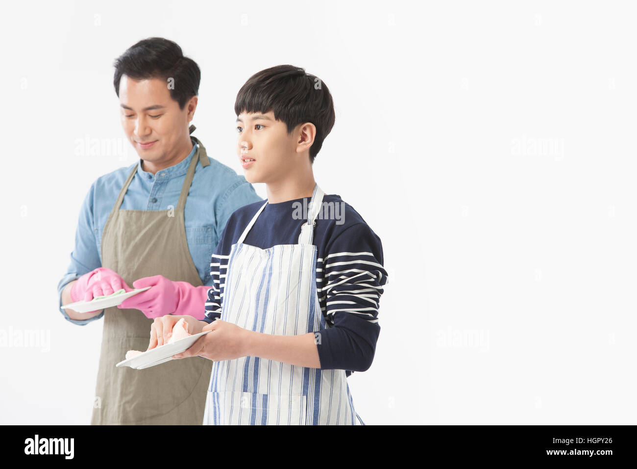 Seitenansicht von Vater und Sohn das Geschirr abwaschen Stockfoto