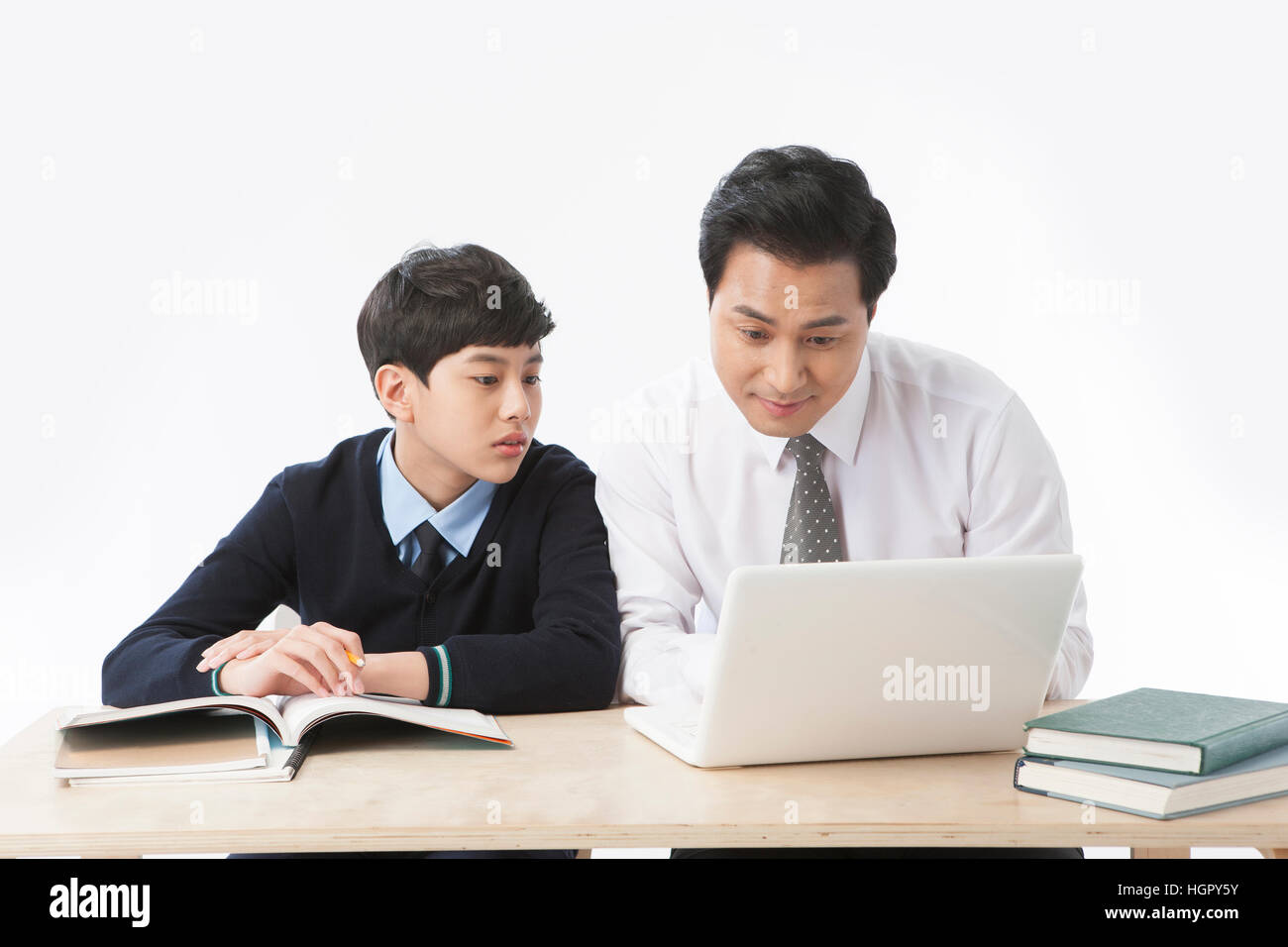 Porträt des Lehrers mit Notebook-Computer und Schule Jungen beobachten Stockfoto