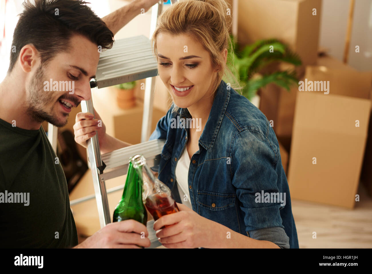 Junges Paar, toasten Bier im neuen Zuhause Stockfoto