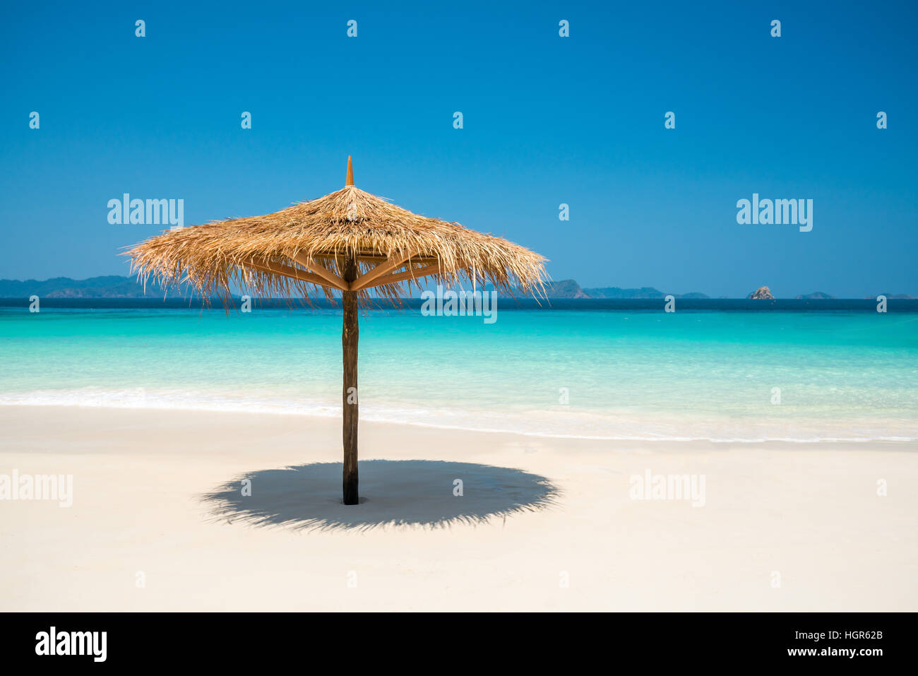 Sonnenschirm, machte der Blätter auf weißen Strand vor dem Meer Tag Zeit blauen Himmel Breite Schuss Hintergrund, Nyaung Oo Phee, Myanmar Stockfoto