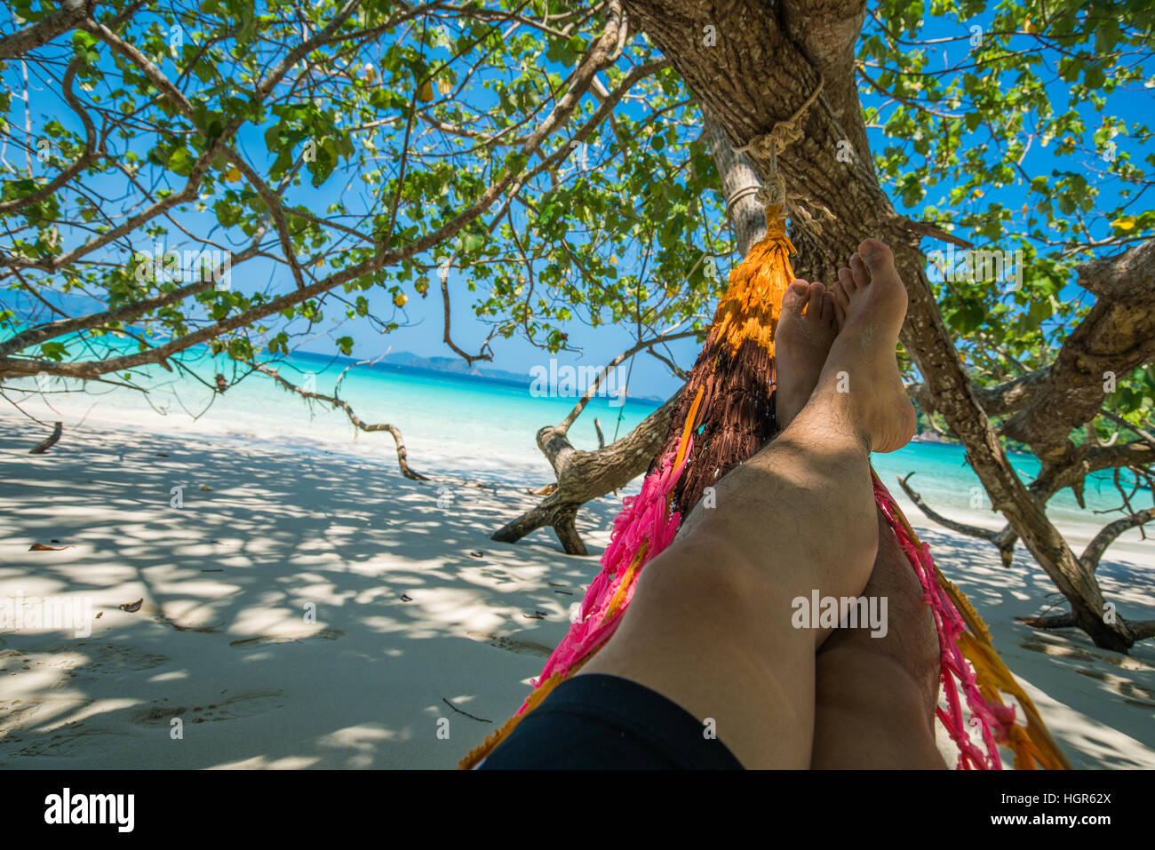 Mann schlafen Baumgurten Hängematte hängen über den Strand im Schatten am Tag Zeit Breite Schuss Hintergrund in Nyaung Oo Phee, Myanma Stockfoto