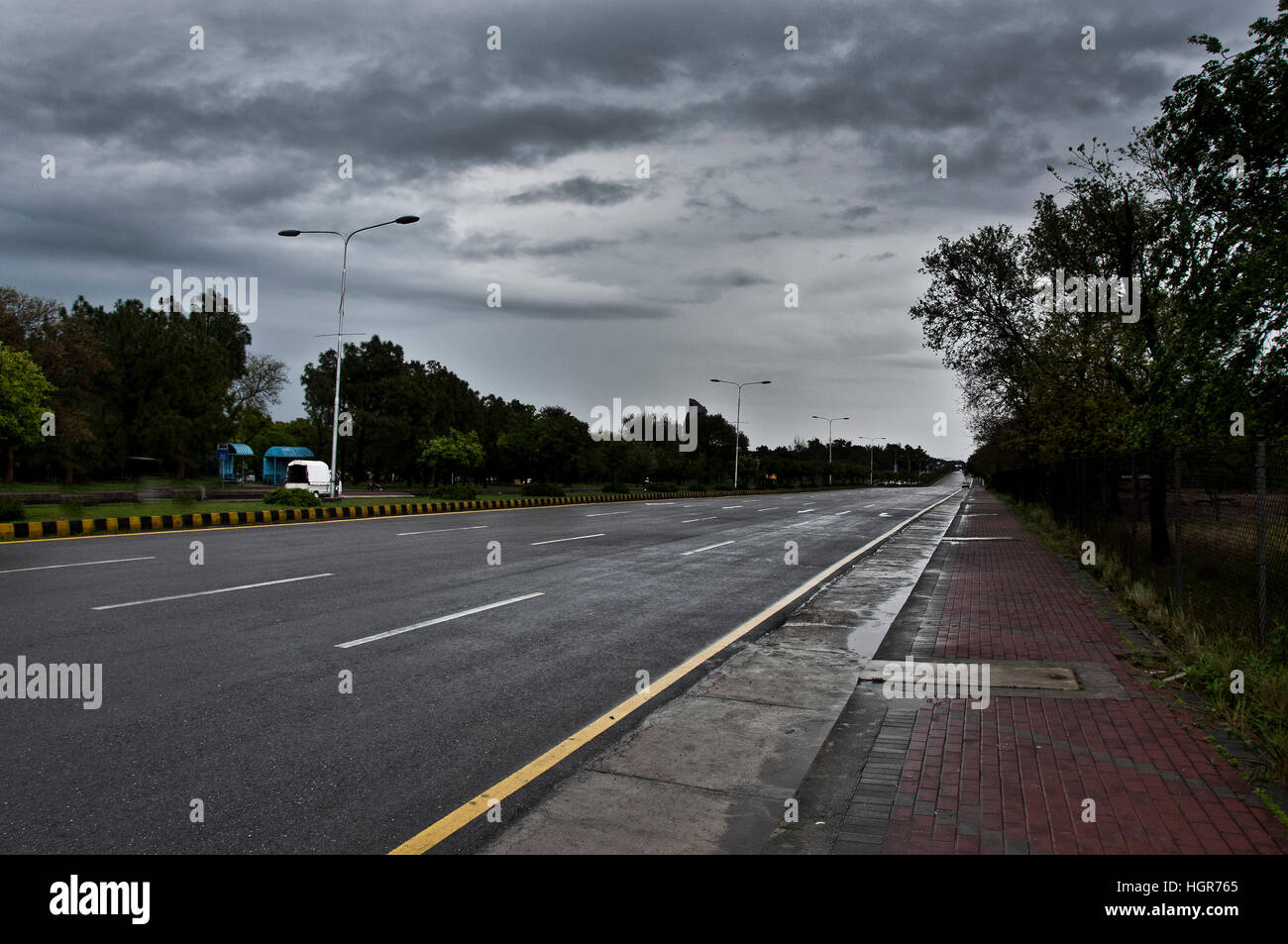 Leerer Straße in der Stadt mit dunklen Wolken im Hintergrund. Stockfoto
