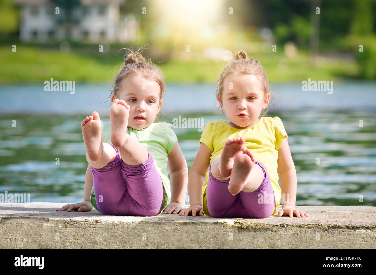 Zwillinge sind am Ufer eines Sees ausüben. Kinder in der Natur am Ufer eines Sees. Stockfoto