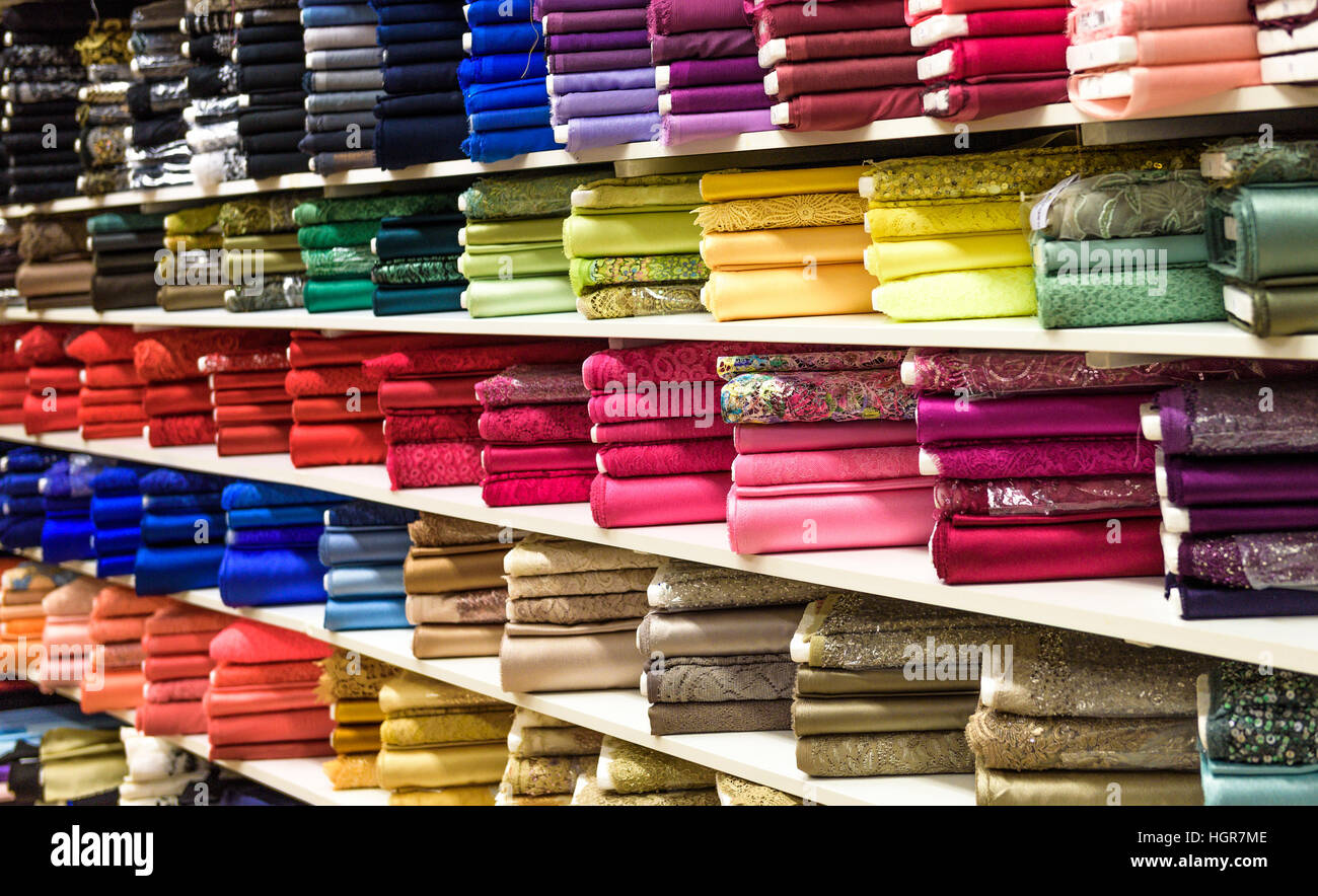Rollen aus Stoff und Textilien in einen Fabrikverkauf. Mehrere verschiedene Farben und Muster auf dem Markt. Stockfoto
