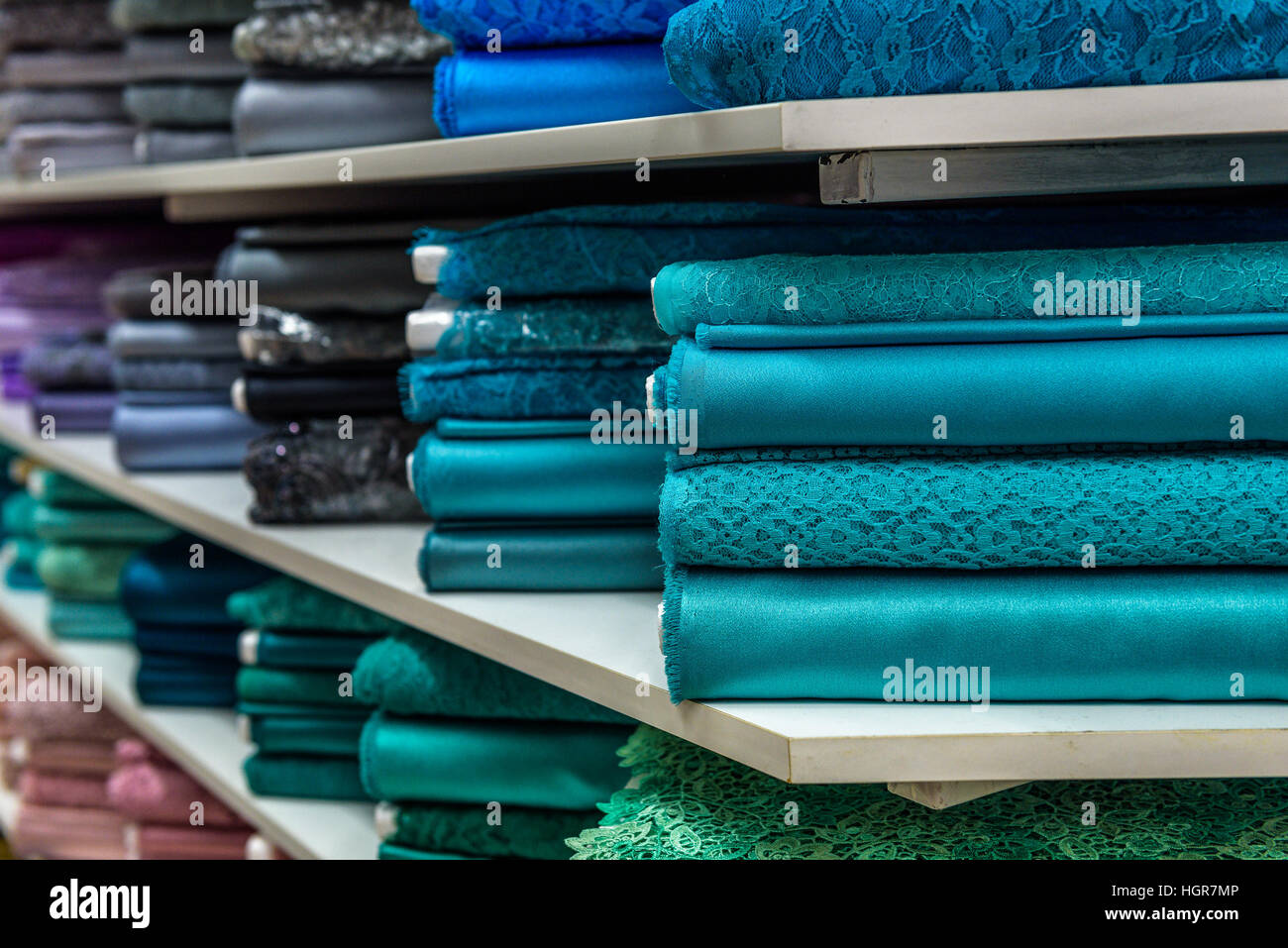 Rollen aus Stoff und Textilien in einen Fabrikverkauf. Mehrere verschiedene Farben und Muster auf dem Markt. Stockfoto