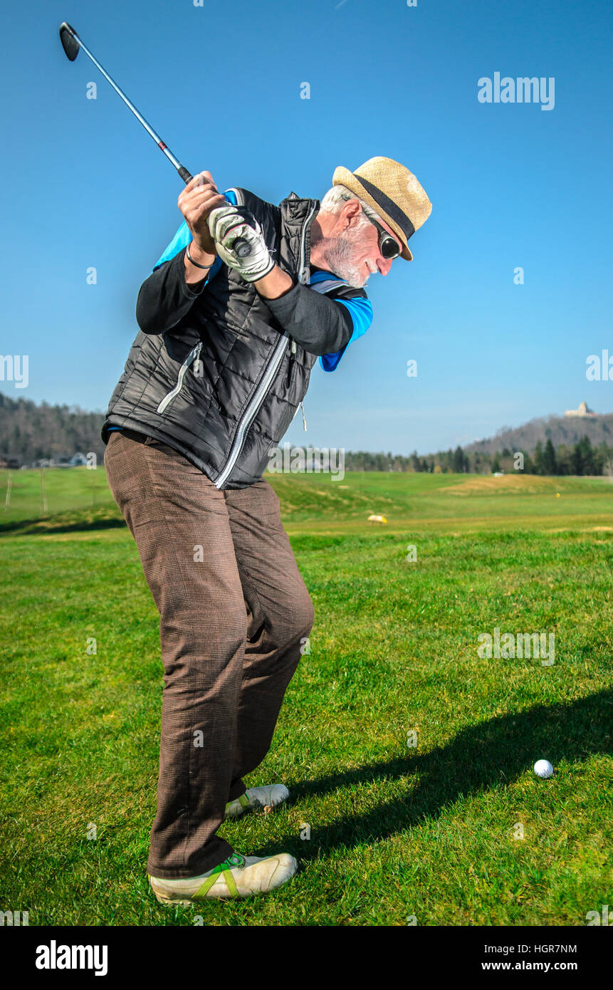 Senioren spielt Golf. Aktiven Ruhestand. Ein Mann ist Golfen, um in Form zu  bleiben. Auf dem grünen Rasen mit Wald im Hintergrund Stockfotografie -  Alamy