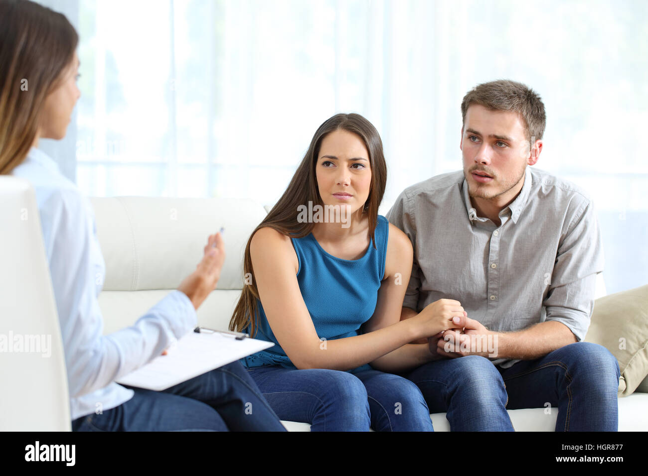 Besorgt paar Eheberater während einer Therapie sitzen auf einem Sofa zu Hause anhören Stockfoto