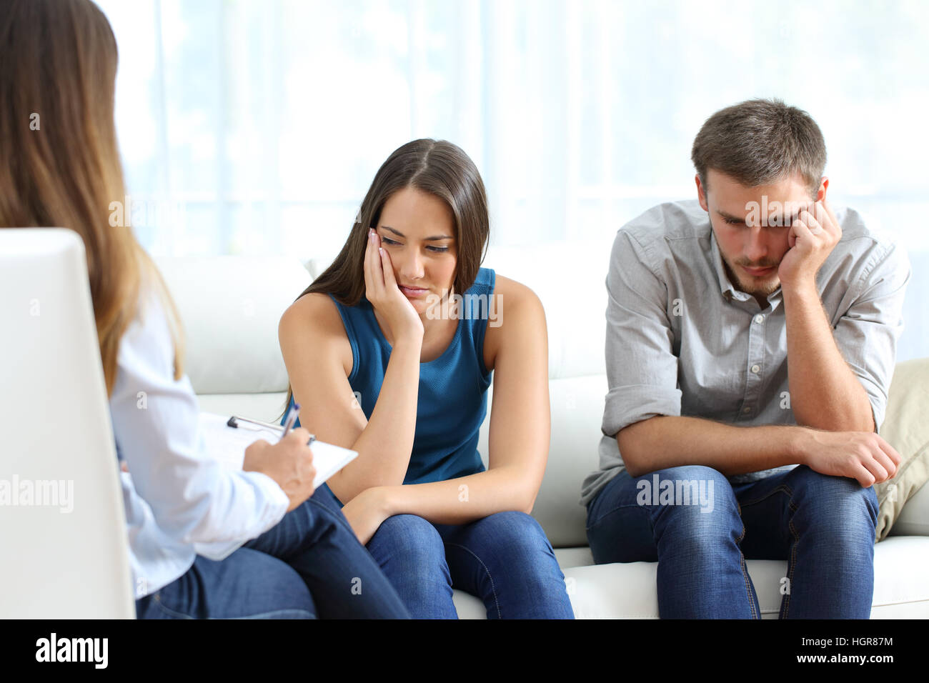 Traurig paar hören zu einem Eheberater während einer Therapie sitzen auf einem Sofa zu Hause Stockfoto