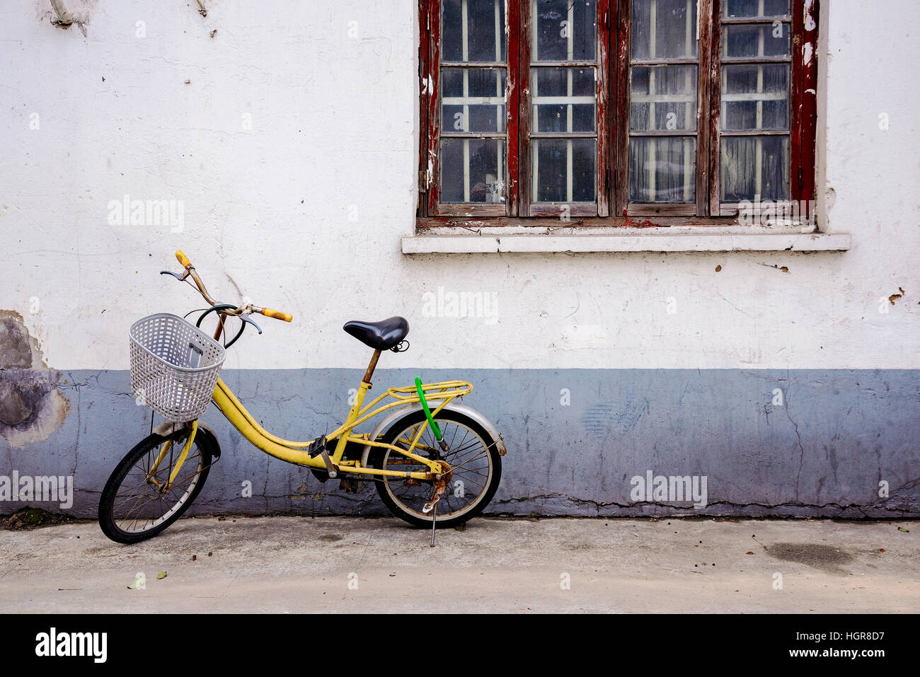 Alte Gasse mit alten gelben Fahrrad und rissige Wand in Shanghai China Stockfoto