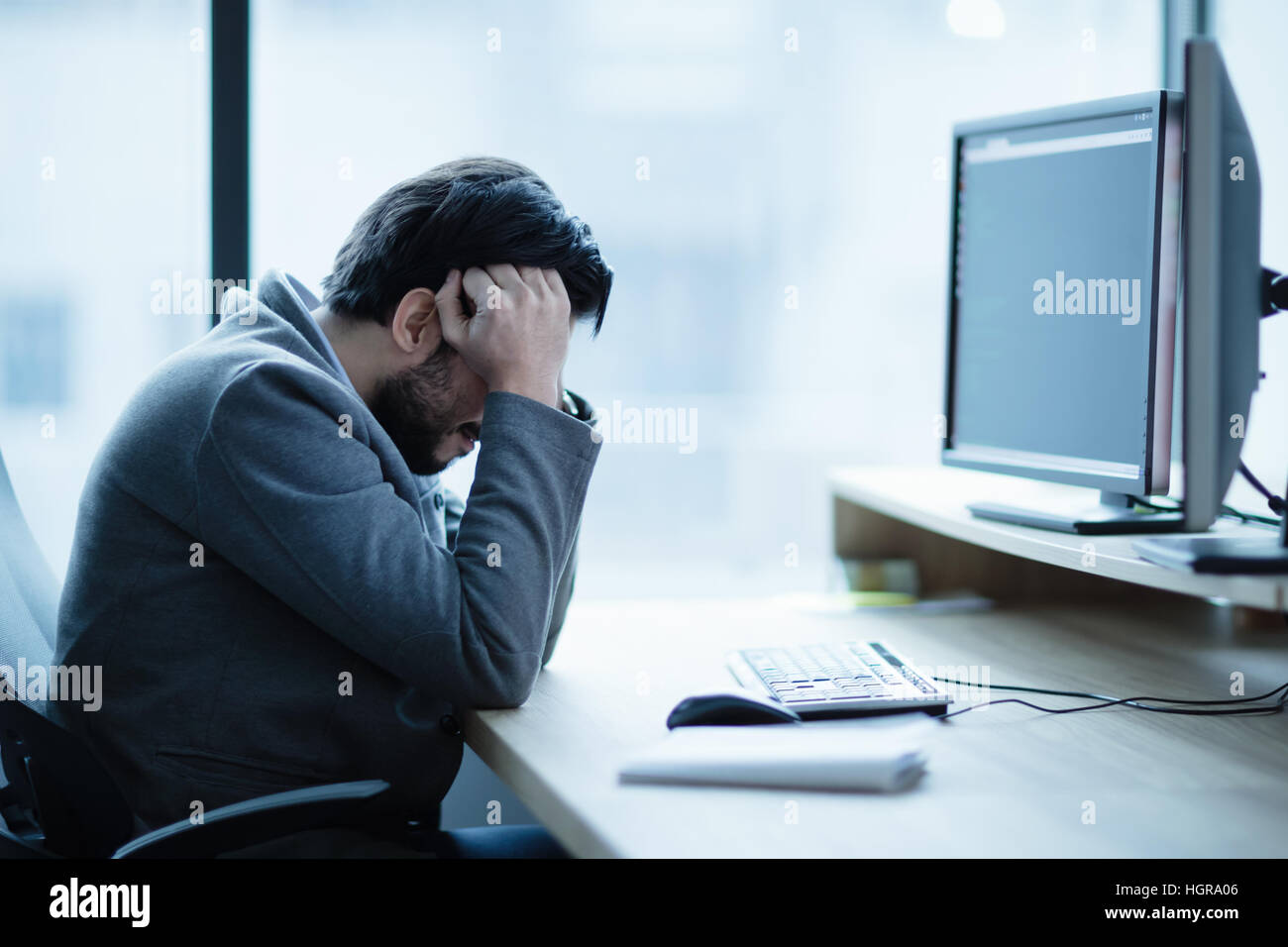 Deprimiert verärgert Büroangestellter mit einer Kopfschmerzen Problem und Arbeitsplatz-Krise Stockfoto