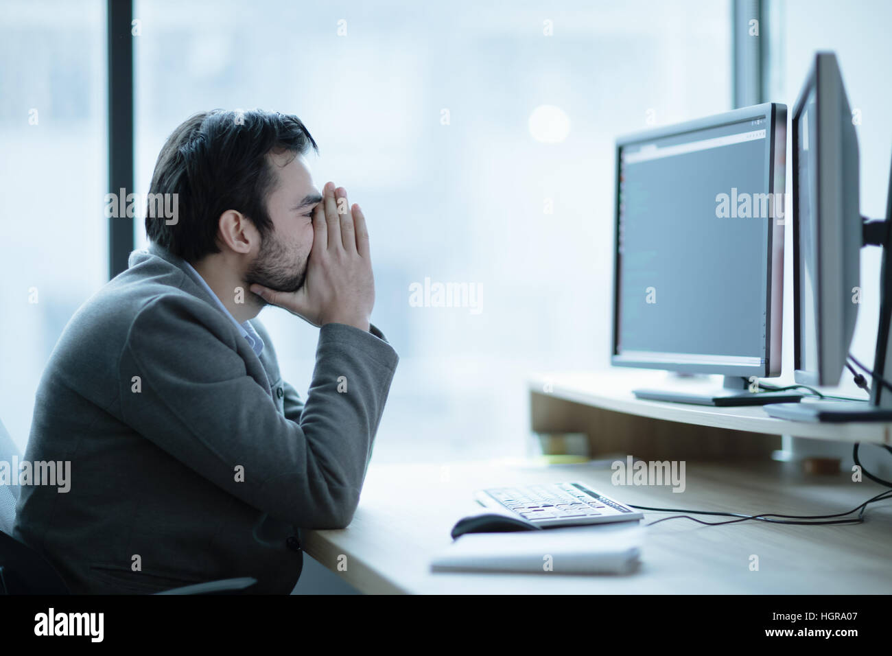 Deprimiert verärgert Büroangestellter mit einer Kopfschmerzen Problem und Arbeitsplatz-Krise Stockfoto