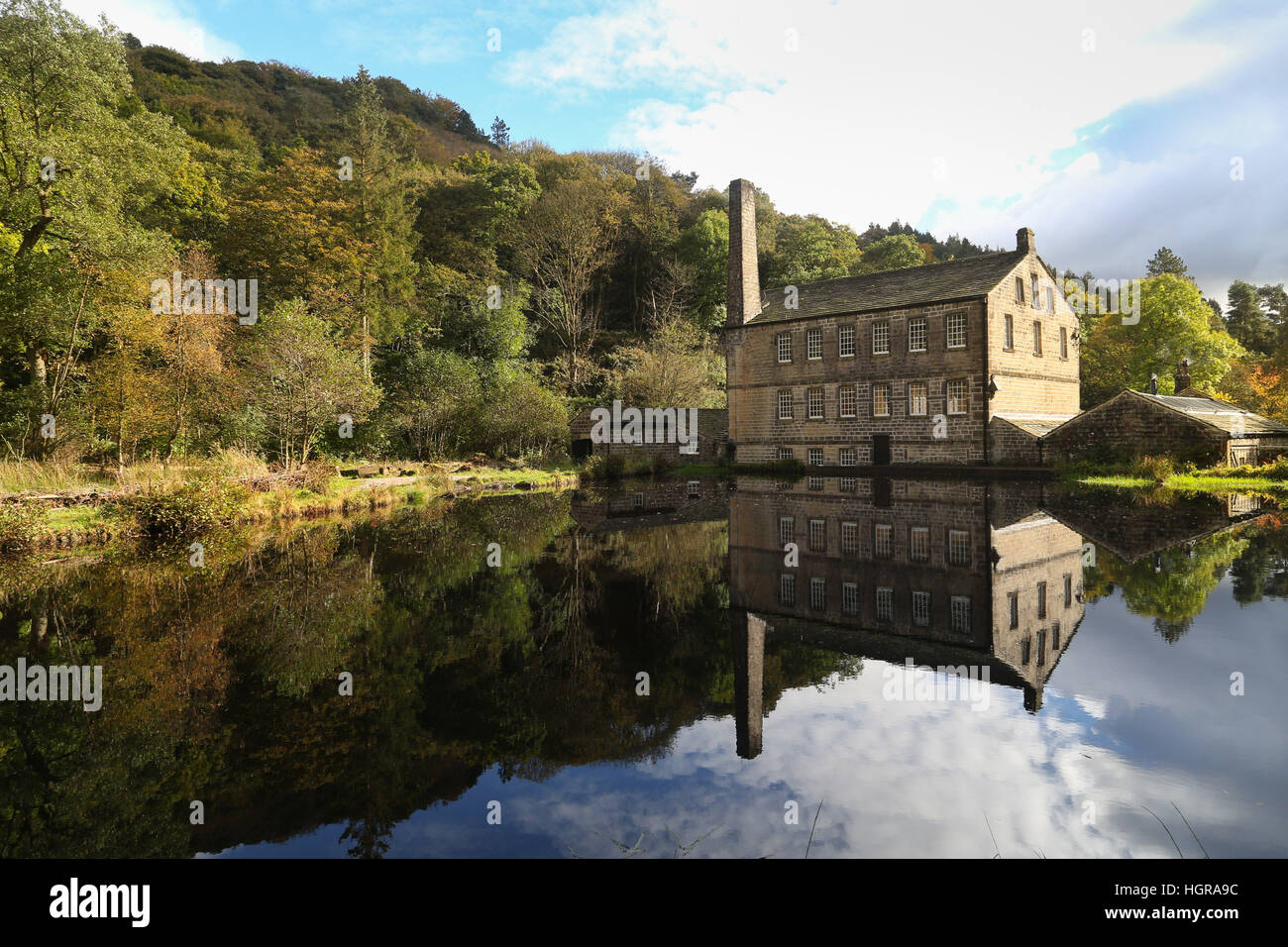 Die Gibson Mill spiegelt sich im Wasser auf einem bunten und sonnigen Herbsttag an hardastle Klippen in der Nähe von Halifax, West Yorkshire. Stockfoto