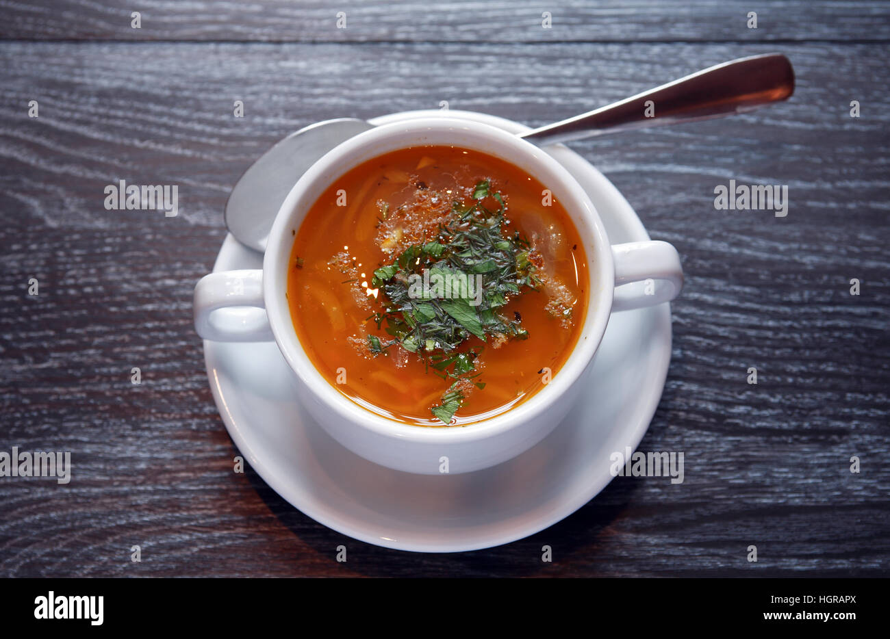 Schüssel mit Suppe auf dunklen Holztisch Stockfoto