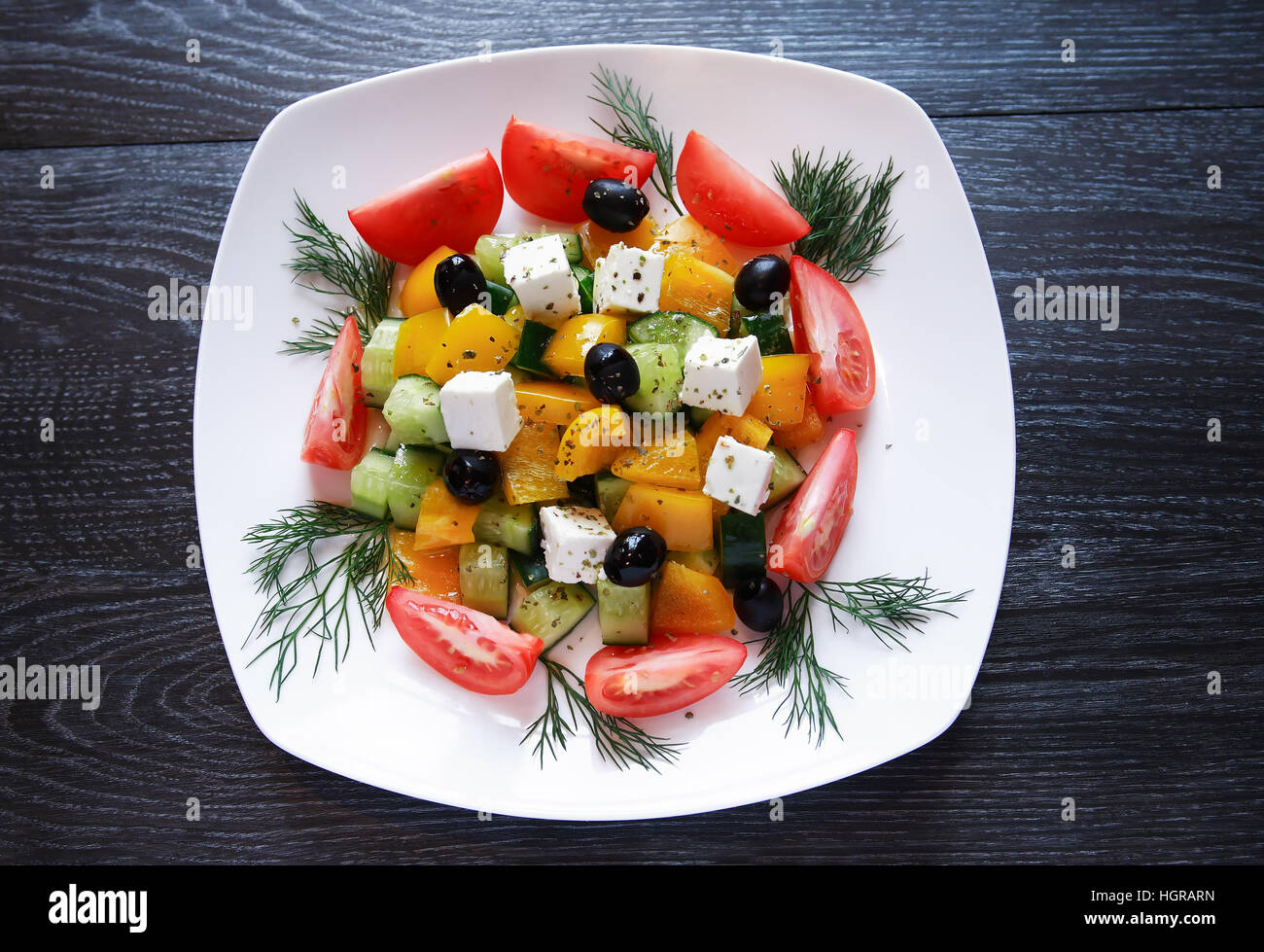 Aperitif zum Abendessen. Platte mit griechischer Salat auf dunklen Holztisch Stockfoto