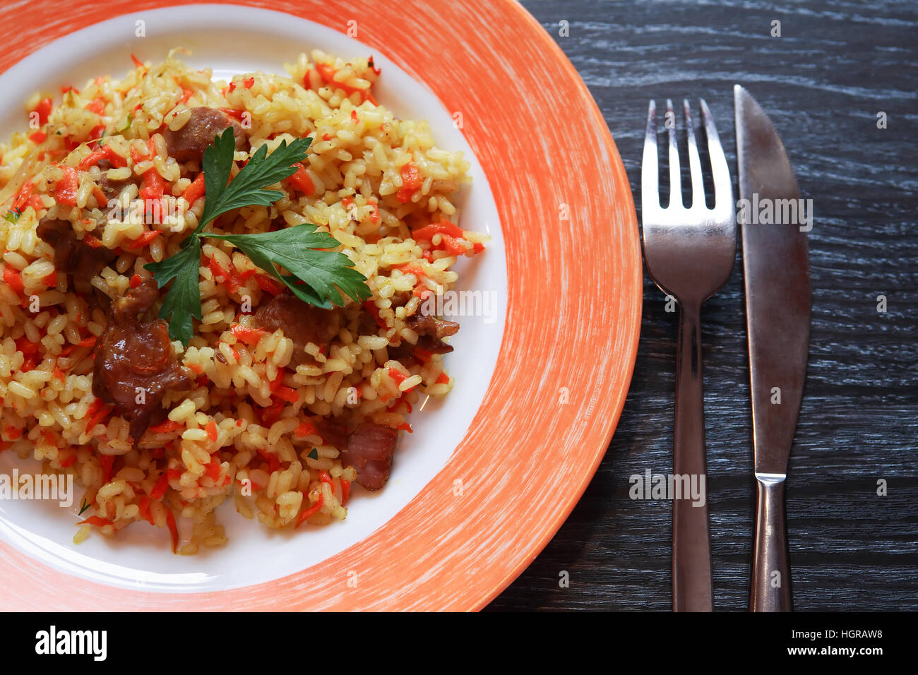 Platte mit Pilaw auf Platte Closeup auf dunklen Holztisch mit freiem Speicherplatz Stockfoto