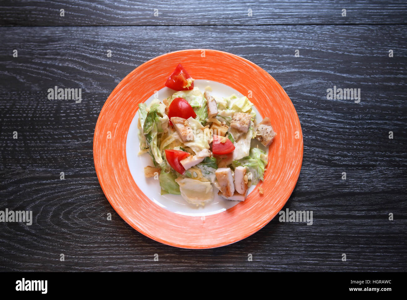 Aperitif zum Abendessen. Teller mit Huhn und Gemüse auf dunklen Holztisch Stockfoto