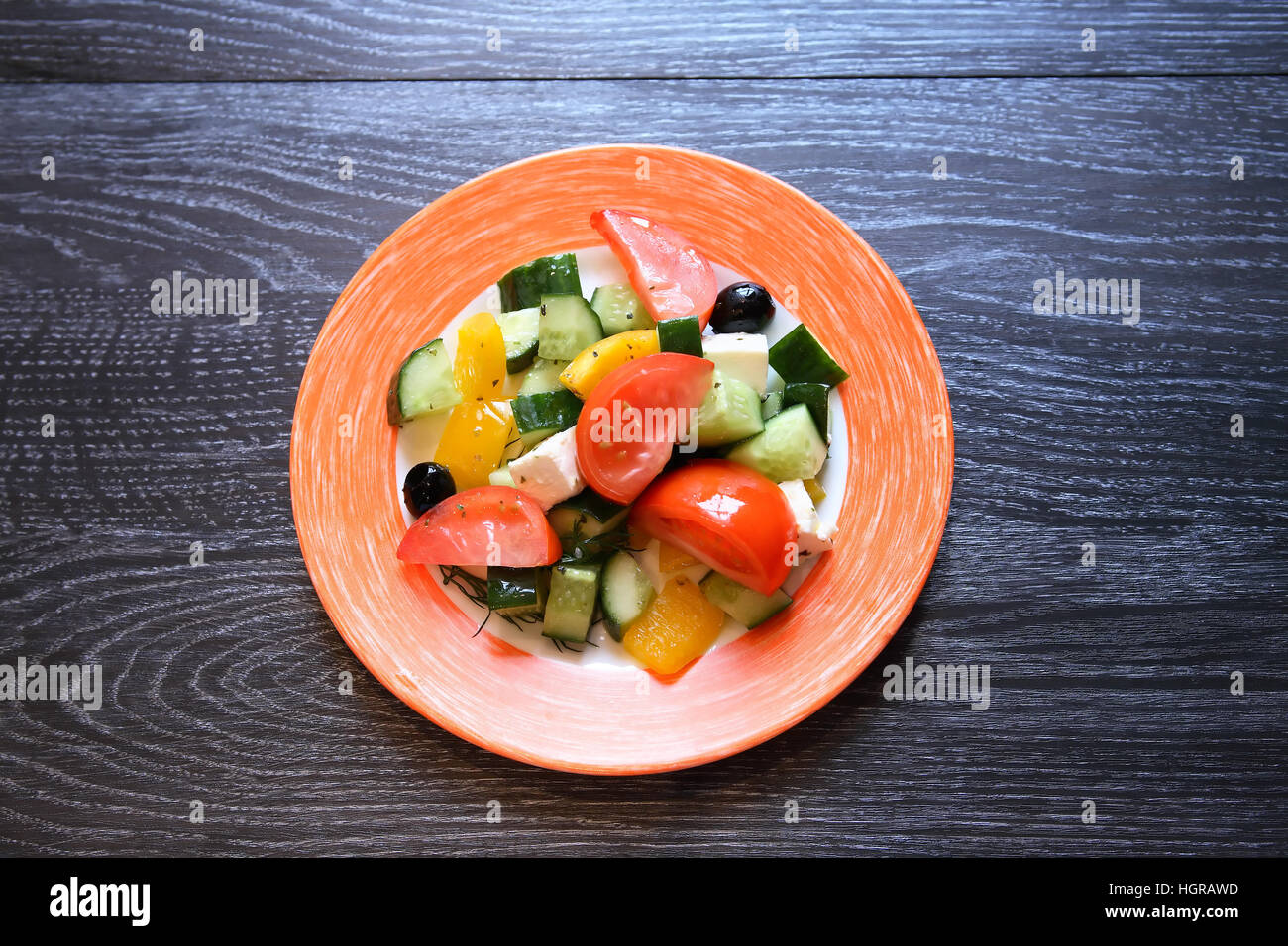 Aperitif zum Abendessen. Teller mit Salat auf dunklem Holz Stockfoto