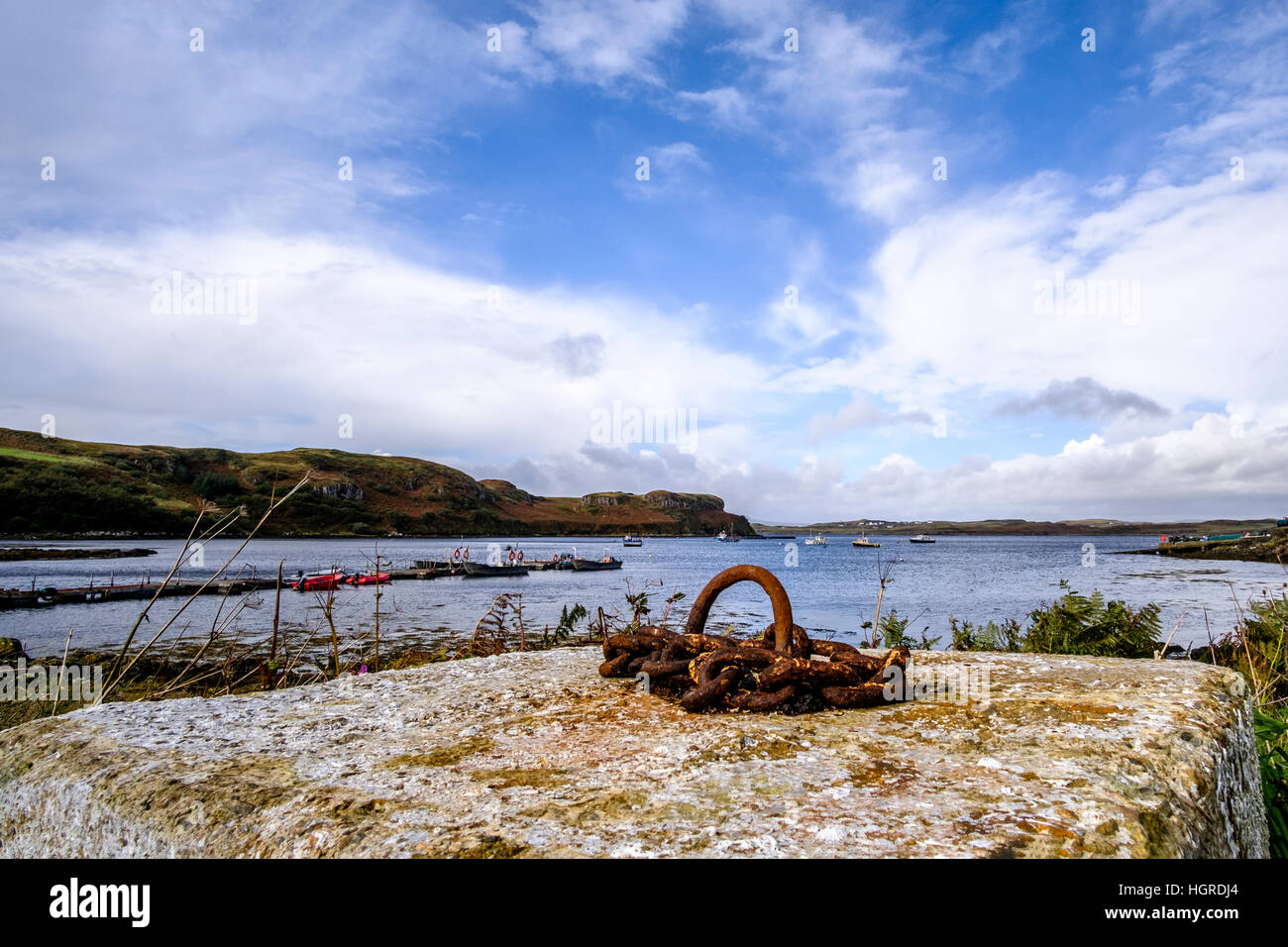 Wunderschöne Bucht in Isle Of Skye Schottland mit kleinen Booten, zerklüftete Küste und Betonblock mit Rosten festmachen Ring im Vordergrund Stockfoto