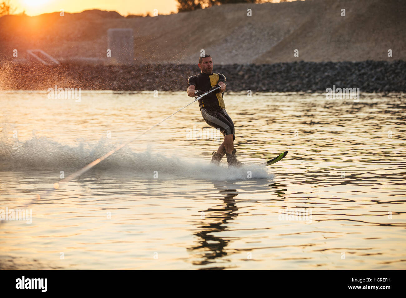 Im Freien Schuss des Mannes Wakeboarding auf See. Wasserski auf See hinter einem Boot. Stockfoto