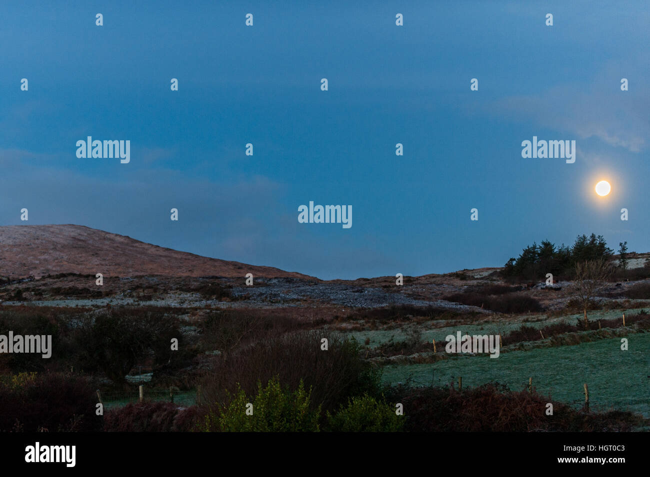 Ballydehob, Irland. 13. Januar 2017.  Eine 98 % abnehmenden Crescent Moon setzt über Mount Corrin, in der Nähe von Ballydehob, West Cork nach über Nacht Temperaturen unter dem Gefrierpunkt, stürzte. Dies führte zu starkem Frost an diesem Morgen, Rendern die Landstraßen sehr tückisch. © Andy Gibson/Alamy Live-Nachrichten. Stockfoto