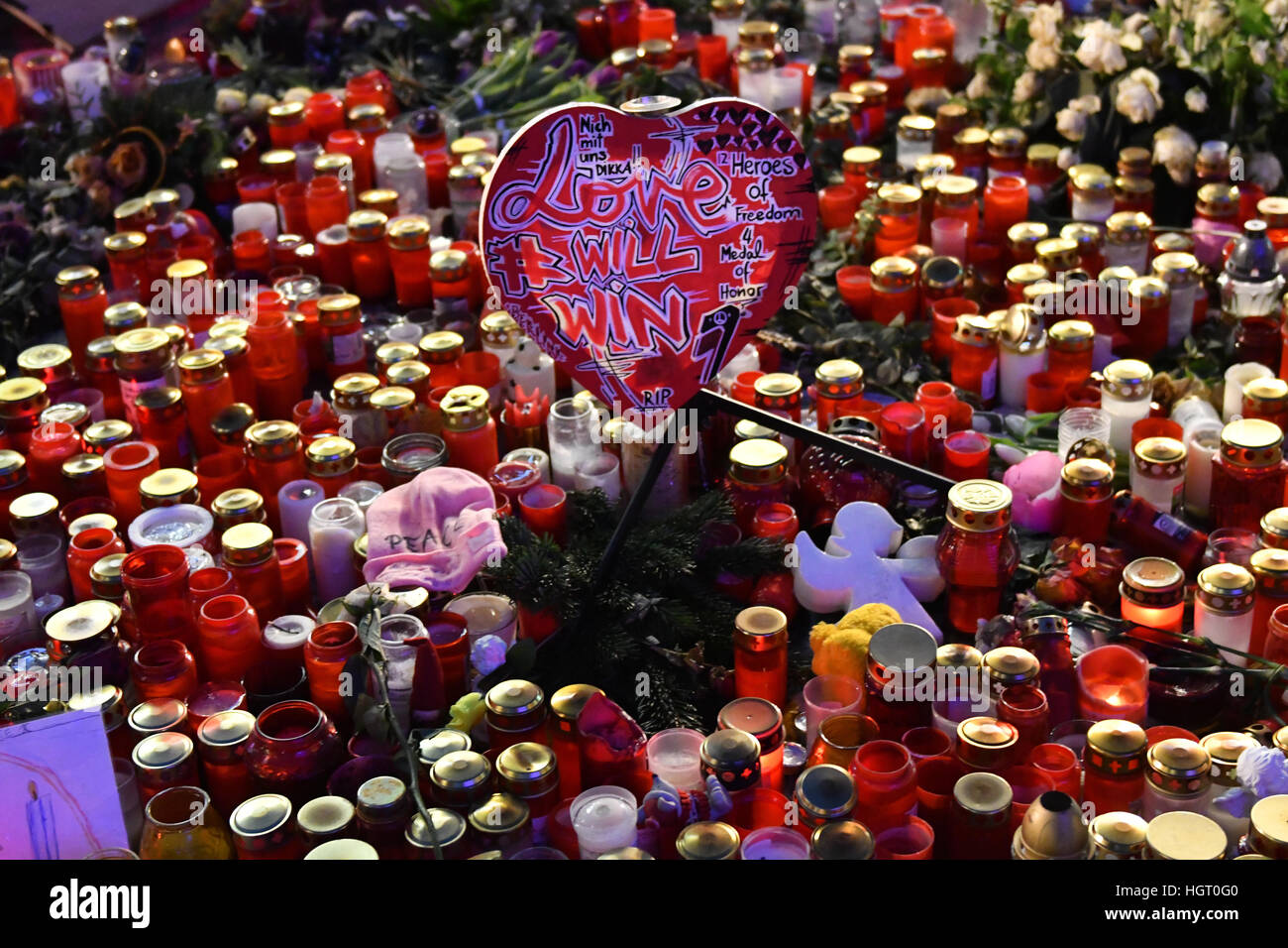 Berlin, Deutschland. 12. Januar 2017. "Liebe gewinnt" steht auf einem herzförmigen Schild in der Mitte von unzähligen Blüten am Breitscheidplatz-Platz in Berlin, Deutschland, 12. Januar 2017. Zwei Gedenken Bereiche bieten noch einen Ort für Gebete und Erinnerung an die Opfer von Terror-Anschlag. Foto: Paul Zinken/Dpa/Alamy Live News Stockfoto