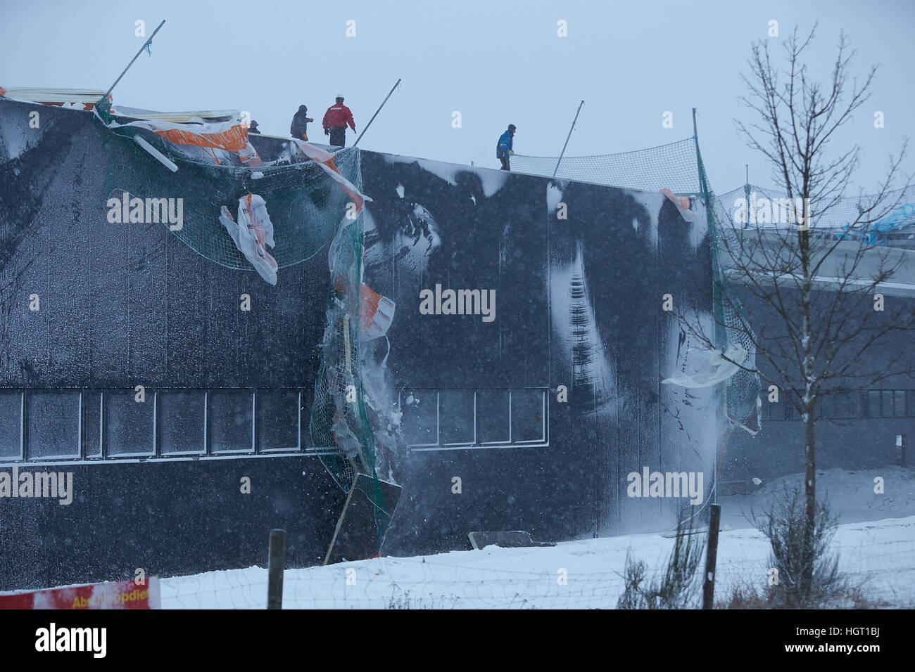 Simmern, Deutschland. 13. Januar 2017. Arbeitnehmer sichern Dämmplatten auf dem Dach einer Halle, die noch im Bau im Industriepark in Simmern, Deutschland, 13. Januar 2017 ist. Die nahe gelegenen Bundesstraße 50 wurde Severa stundenlang durch die Dämmplatten, die im Sturm herumfliegen wurden geschlossen. Foto: Thomas Frey/Dpa/Alamy Live News Stockfoto