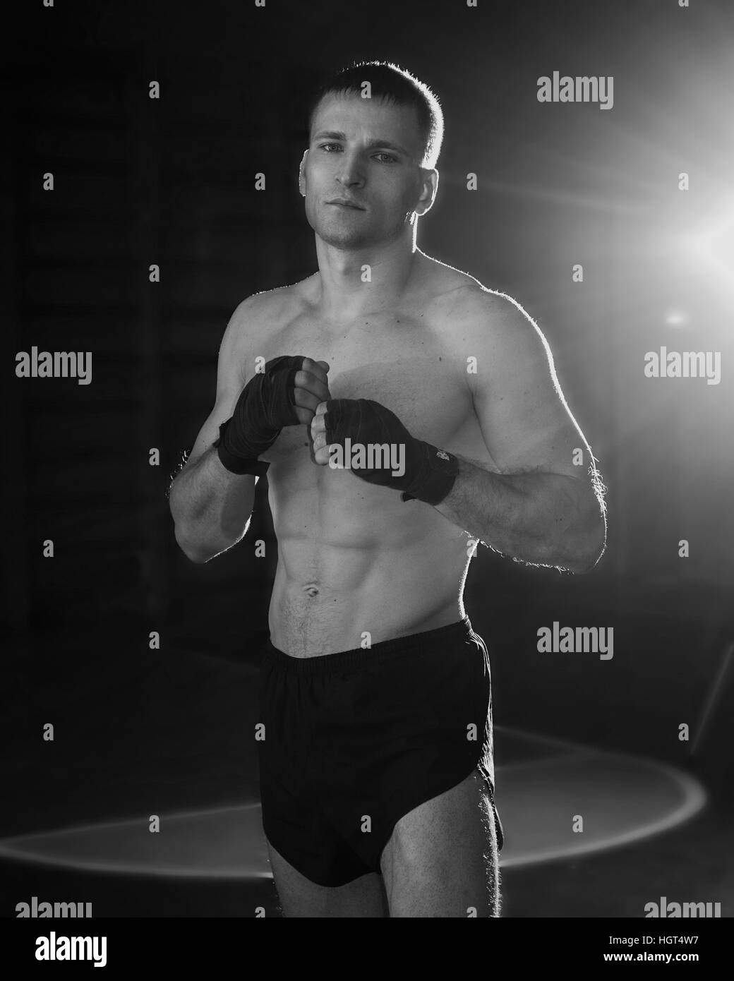 Junger sportlicher Mann mit Box-Bandagen auf seine Hände. Schwarz / weiß Foto Stockfoto