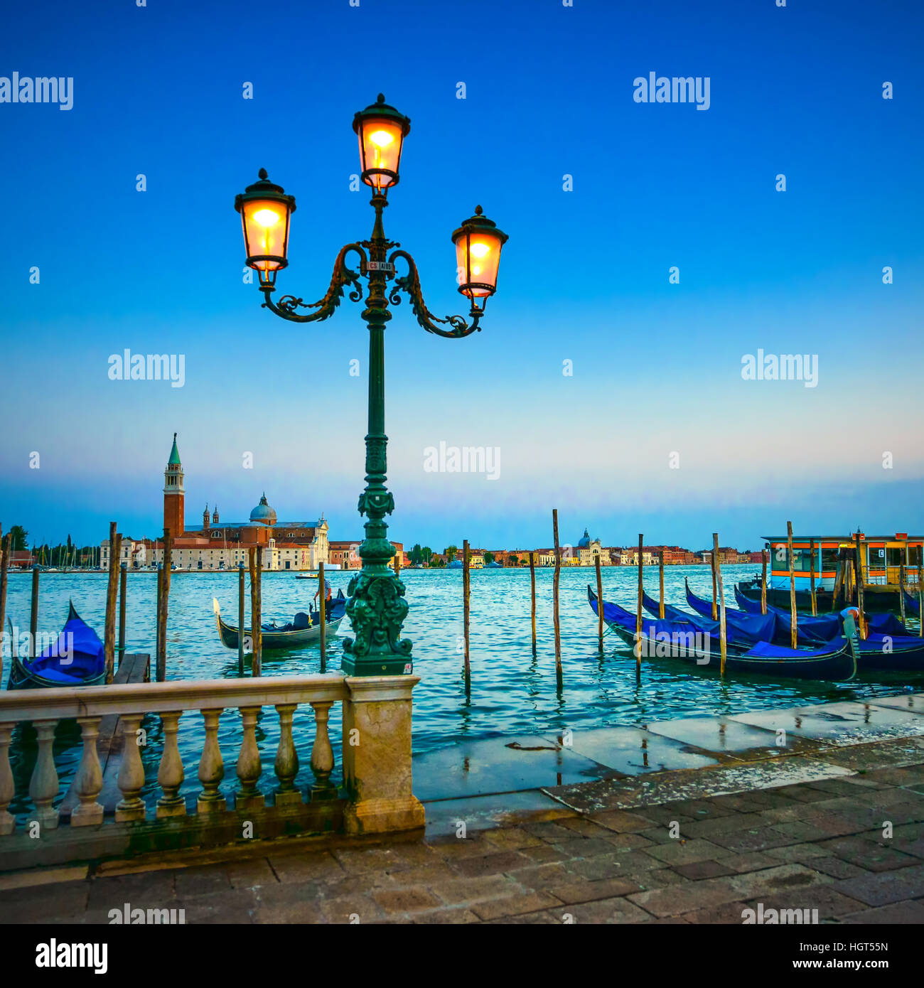 Venedig, Straßenlaterne und Gondeln oder Gondeln auf einem blauen Sonnenuntergang Dämmerung und San Giorgio Maggiore Kirche Wahrzeichen auf Hintergrund. Italien, Europa. Stockfoto