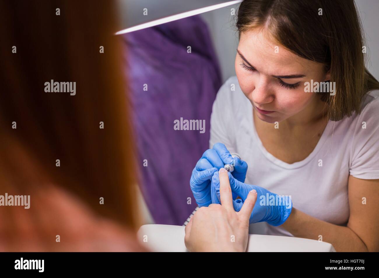 Hardware-Maniküre in einem Salon. Maniküre ist die elektrische Nagelfeile Drill Anwendung Stockfoto