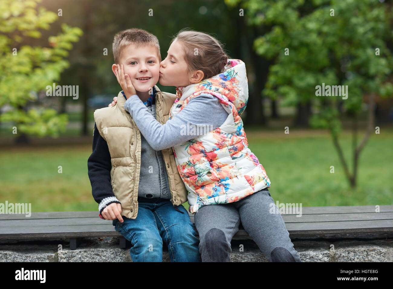 Geben ihrem kleinen Bruder einen Kuss außerhalb Stockfoto